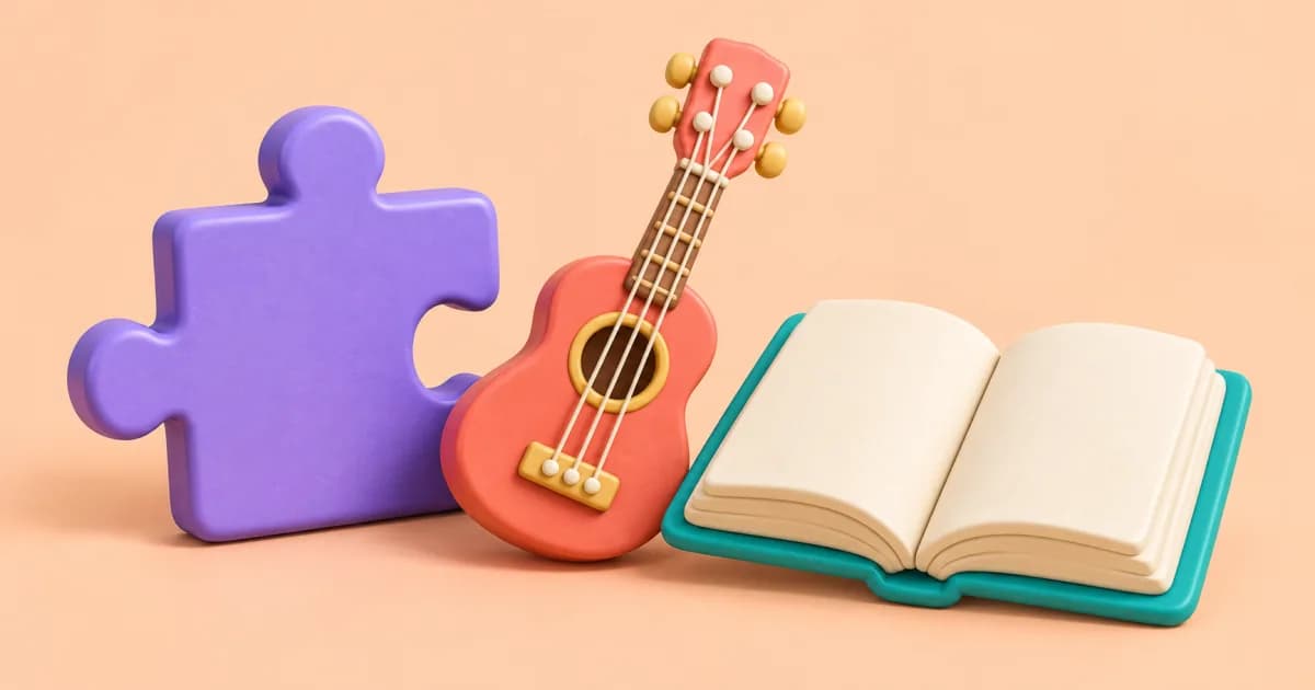 A clay puzzle piece, a small ukulele and an open book on a light peach surface.